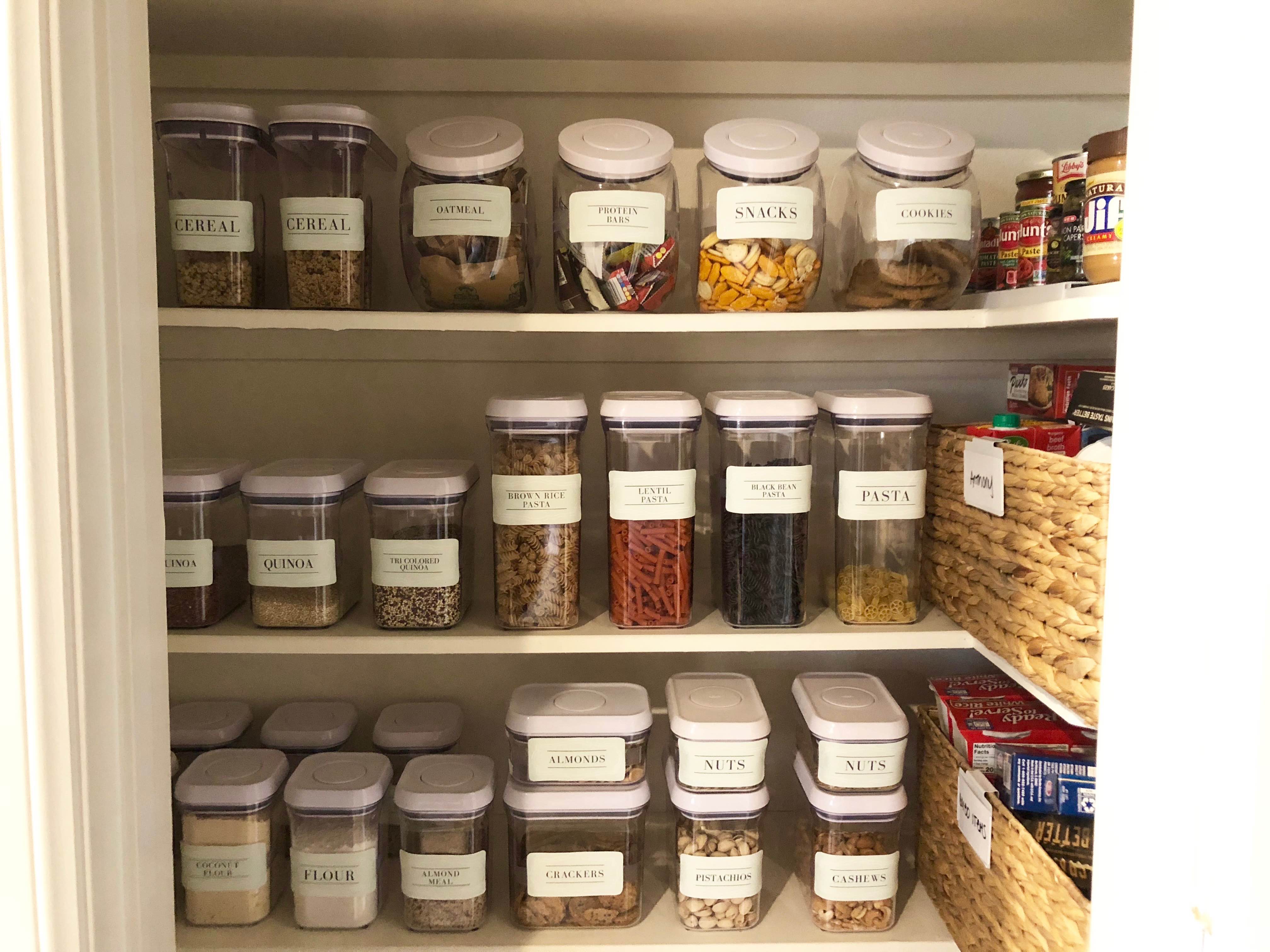 Well-labeled pantry shelves with clear containers grouped by food category